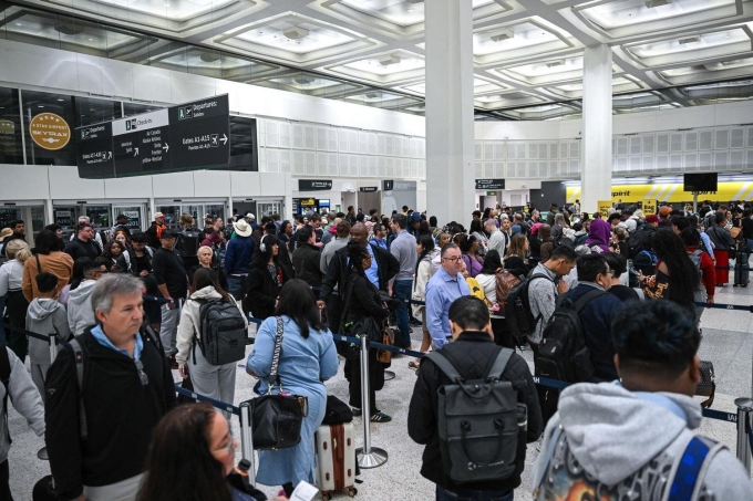 Travelers wait in line at a TSA security checkpoint at George Bush Intercontinental Airport in Houston, Texas. PHOTO BY RONALDO SCHEMIDT / AFP VIA GETTY IMAGES