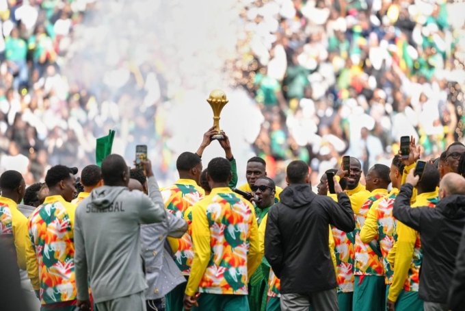 Les joueurs du Sénégal présentent le trophée de la Coupe d’Afrique des nations, avant le coup d’envoi de leur match amical contre le Pérou, le 28 mars au Stade de France. AURELIEN MORISSARD / AP