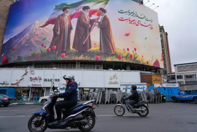 Sur une affiche géante de propagande placardée dans le centre de Téhéran, les ayatollahs Rouhollah Khomeiny et Ali Khamenei remettent symboliquement le pouvoir à Mojtaba Khamenei, le 10 mars 2026. Vahid Salemi, AP