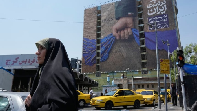 This billboard in Tehran depicts a hand squeezing the Strait of Hormuz. The words in Farsi include, 'In Iran's hands forever," and 'Trump couldn't do a damn thing.' (Vahid Salemi/The Associated Press)