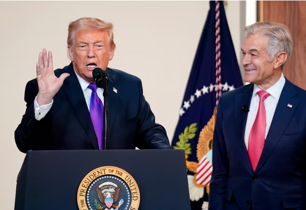 Donald Trump speaks as the administrator for the Centers for Medicare and Medicaid Services, Mehmet Oz, looks on in Washington DC in February. Photograph: Nathan Howard/Getty Images