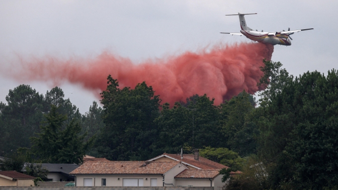 Un avion largue un produit ignifuge à Marcheprime, dans le département de la Gironde.  Photo : Reuters / Florion Goga