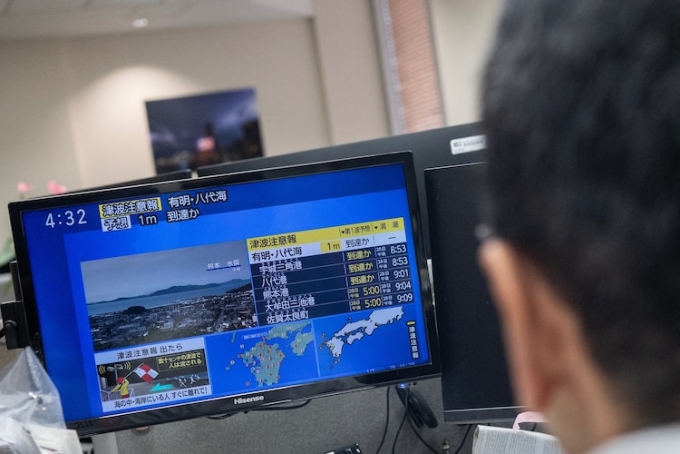 Reporters watch the news showing a large quake and possible one meter tsunami wave in Southern Japan, from an office in Tokyo on July 28, 2026. Andrew Caballero-reynolds/AFP via Getty Images