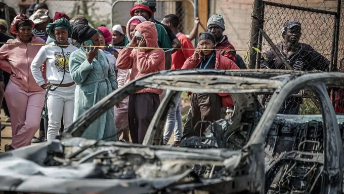 Getty Images Gunmen torched vehicles as they fled the scene of a mass shooting at bar near Johannesburg