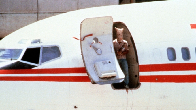 A masked, armed militant stands in the doorway of a TWA Boeing 727 at Beirut airport during a hijacking in 1985 © Joel Robine/AFP/Getty Images