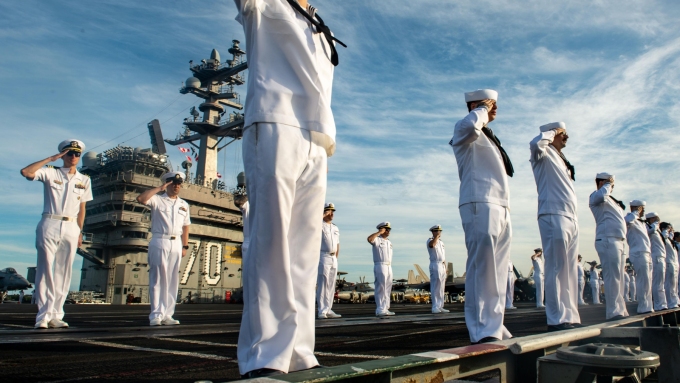 Des marins à bord du USS Carl Vinson, un porte-avion de classe Nimitz, saluent un autre vaisseau qui arrive à la base de Pearl Harbor-Hickam, en juillet 2024.  Photo : US Navy / PO2 Analice Baker