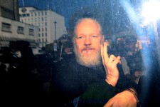 Julian Assange gestures to the media from a police vehicle on his arrival at Westminster Magistrates court on April 11, 2019 in London, England. Jack Taylor, Getty Images