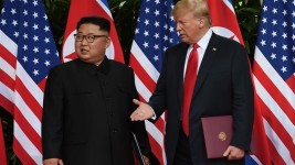 US President Donald Trump and North Korea's leader Kim Jong-un react during their summit at the Capella Hotel on Sentosa island in Singapore June 12, 2018 [Anthony Wallace/Pool via Reuters]