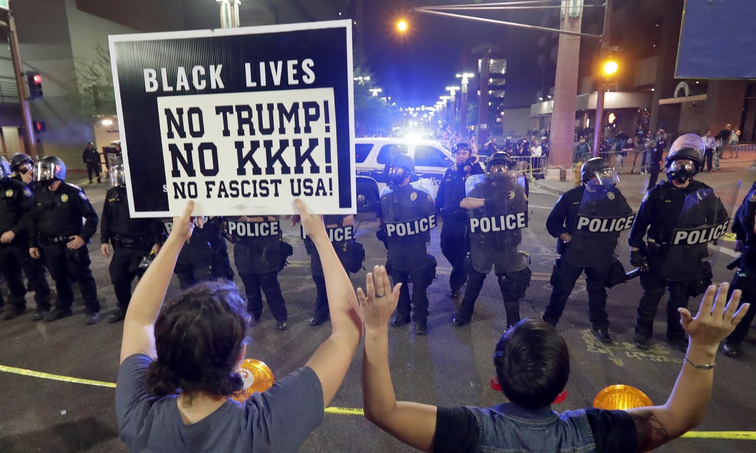 Protesters outside the Trump rally in Phoenix raise their hands after police used teargas to disperse the crowd. Photograph: Matt York/AP