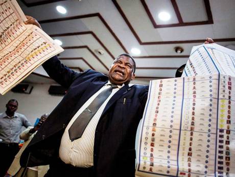 Image Credit: AFP National Electoral Commission official holds up lists of candidates during a presentation showing how new voting machine work, on February 21, 2018 in Kinshasa.