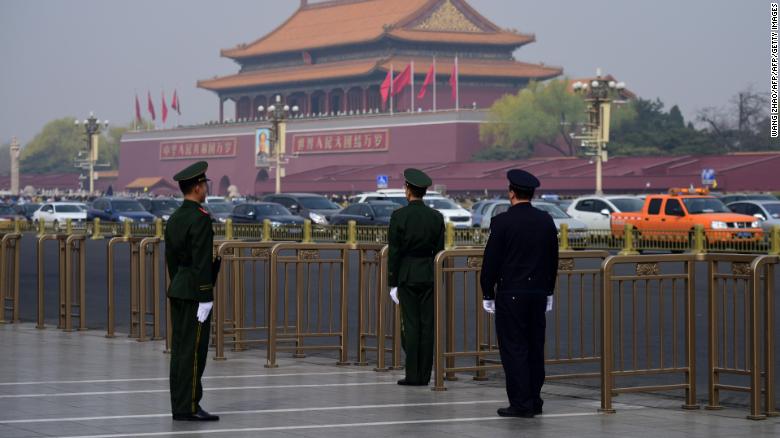 A police and two paramilitary police officers take position near Tiananmen Square on Tuesday.