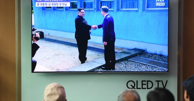 © Jung Yeon-je / AFP | People watch a television screen showing live footage of the inter-Korea summit between South Korean President Moon Jae-in and North Korean leader Kim Jong Un, at a railway station in Seoul on April 27, 2018.