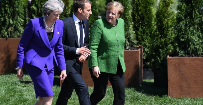 © Saul Loeb, AFP | British Prime Minister Theresa May, French President Emmanuel Macron and German Chancellor Angela Merkel arrive for a family photo during the G7 Summit in in La Malbaie, Quebec, Canada, June 8, 2018.