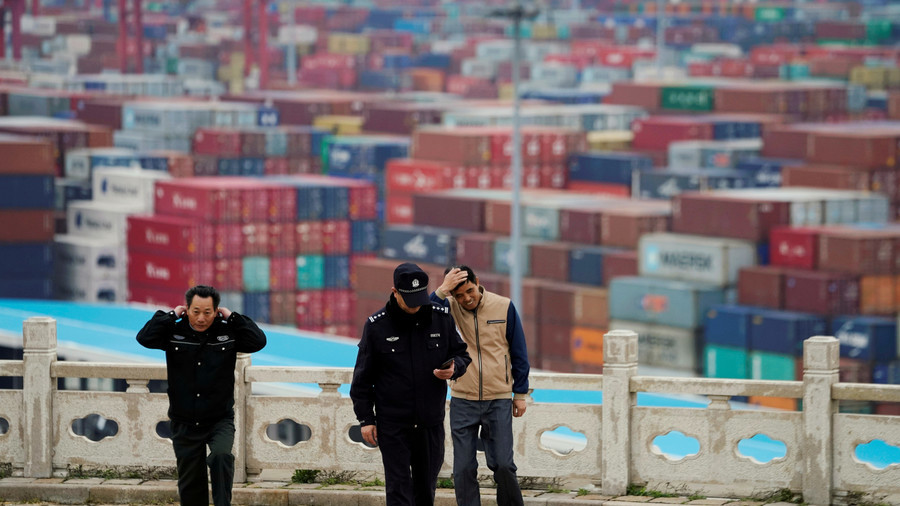 Security guards watch over cargo containers at the Yangshan Deep Water Port in Shanghai, China April 24, 2018. © Aly Song / Reuters