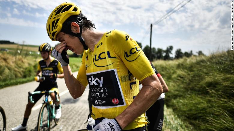 Tour de France leader Geraint Thomas cleans his eyes after tear gas was used during a farmers' protest.