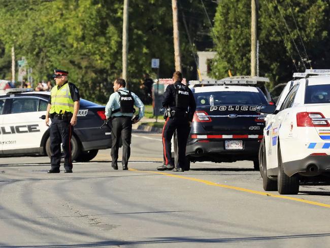 Police and RCMP officers survey the area of a shooting in Fredericton, New Brunswick, Canada. Picture: APSource:AP