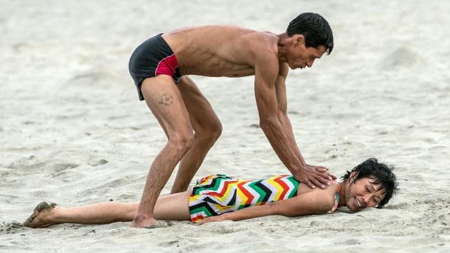 A man gives his wife a massage on the beach on August 22, 2018 in Wonsan, North Korea. Picture: Carl Court/Getty ImagesSource:Getty Images