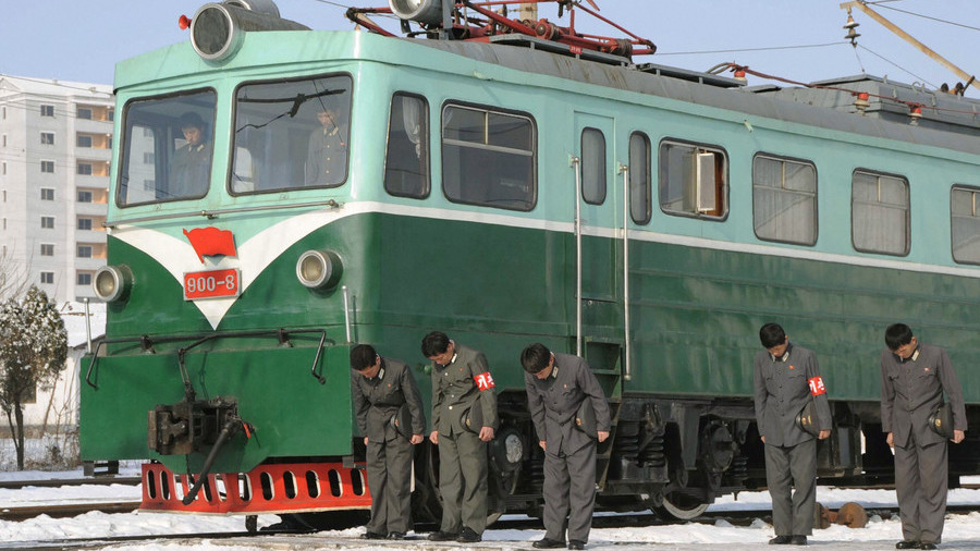 FILE PHOTO: North Korean railway workers next to a train © Kyodo / Reuters