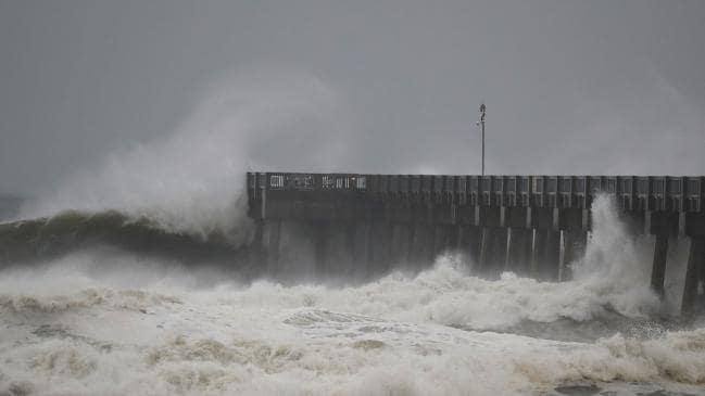 Waves crash along a pier as the outerbands of hurricane Michael arrive on October 10, 2018 in Panama City Beach, Florida. Picture: GettySource:AFP