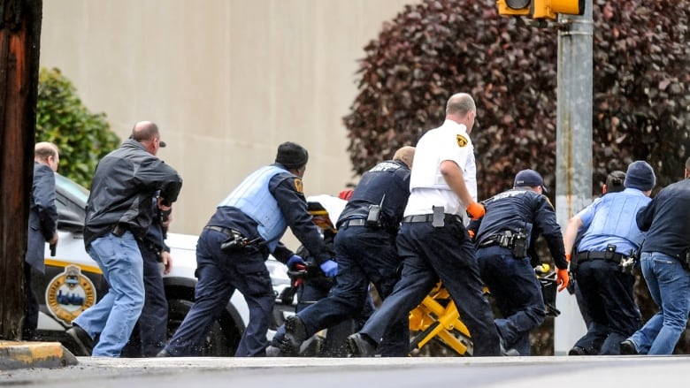 Law enforcement officials run with a person on a stretcher at the scene of Saturday's mass shooting at the Tree of Life Congregation in Pittsburgh. (Alexandra Wimley/Pittsburgh Post-Gazette/AP)