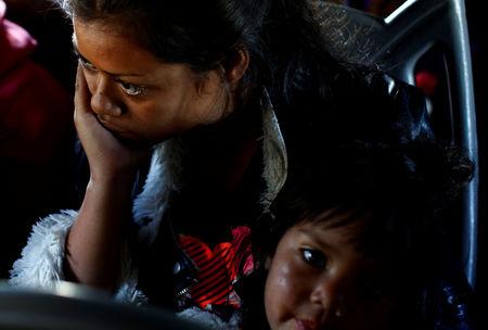 A migrant woman and a girl, part of a caravan of thousands traveling from Central America en route to the United States, sit in a bus while the bus stop for them to get food and water from a store on a highway in Culiacan, Mexico November 15, 2018. REUTER