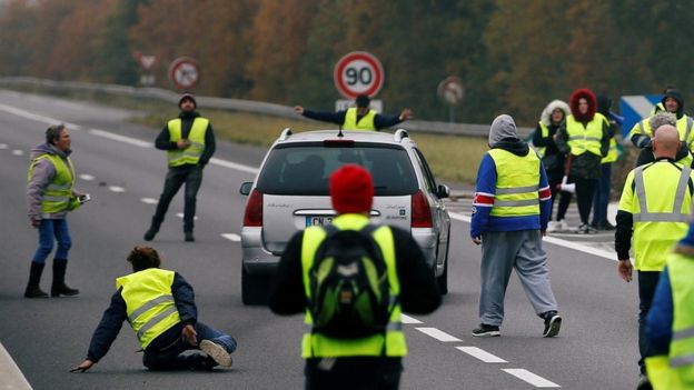 REUTERS / A driver forces a car through a group of protesters in Donges, western France