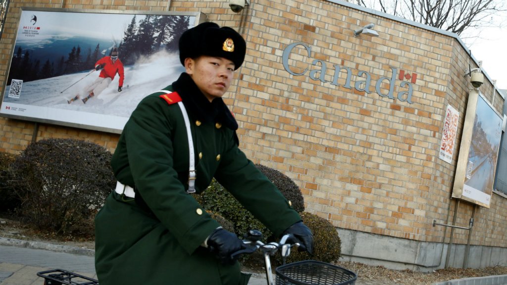 Thomas Peter, Reuters | A paramilitary police officer cycles past the Canadian embassy in Beijing on December 12.