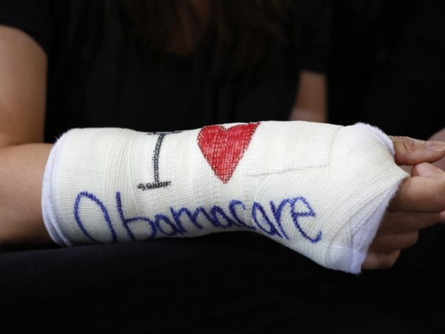 Park of Cambridge wears cast for her broken wrist with "I Love Obamacare" written upon it prior to U.S. President Barack Obama's arrival to speak about health insurance at Faneuil Hall in Boston Thomson Reuters