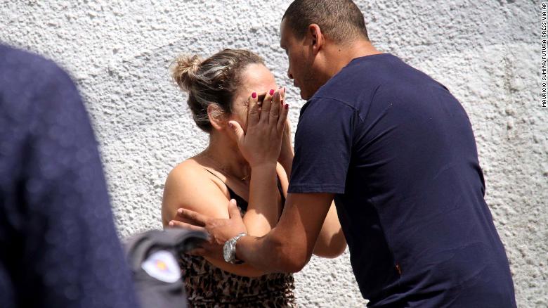 A man comforts a woman at the Raul Brasil State School in Suzano, Brazil, Wednesday after officials said two men shot and killed students and school staff.  A man comforts a woman at the Raul Brasil State School in Suzano, Brazil, Wednesday after official