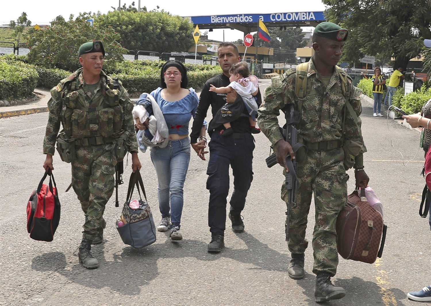 Colombian soldiers escort a Venezuelan policeman, who deserted his post with his family, after crossing the Simon Bolivar International Bridge into La Parada, Colombia on Feb. 27, 2019, on the border with Venezuela.Martin Mejia / AP file
