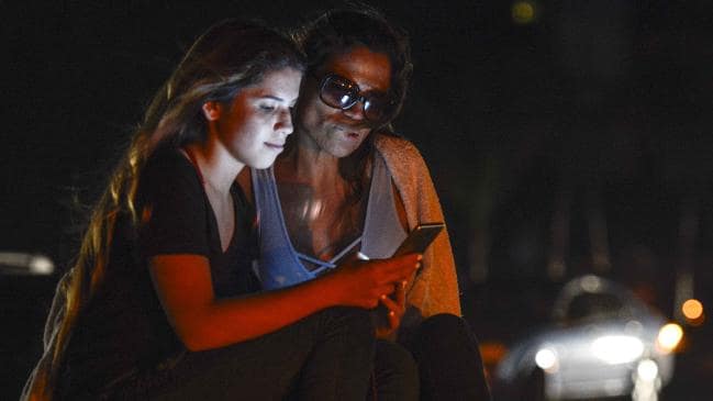 People use their mobile phones during a power outage that Venezuela President Nicolas Maduro said was caused by a cyber attack. Picture: Matias Delacroix/AFPSource:AFP
