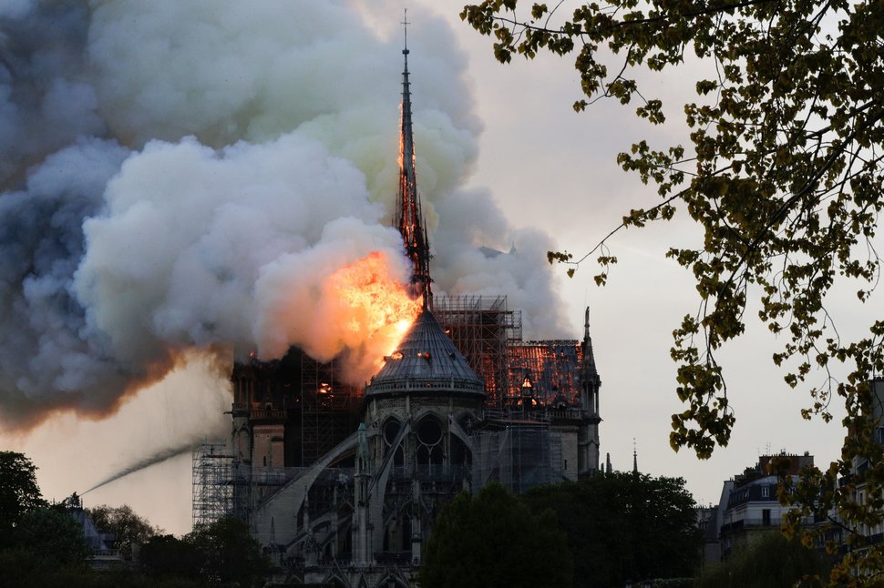 Flames and smoke are seen billowing from the roof at Notre-Dame Cathedral in Paris on April 15, 2019.  / GEOFFROY VAN DER HASSELT VIA GETTY IMAGES