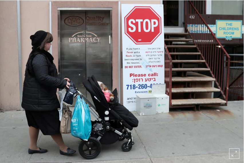 FILE PHOTO: A sign warning people of measles in the ultra-Orthodox Jewish community of Williamsburg, two days after New York City Mayor Bill de Blasio declared a public health emergency in parts of Brooklyn in response to a measles outbreak, is seen