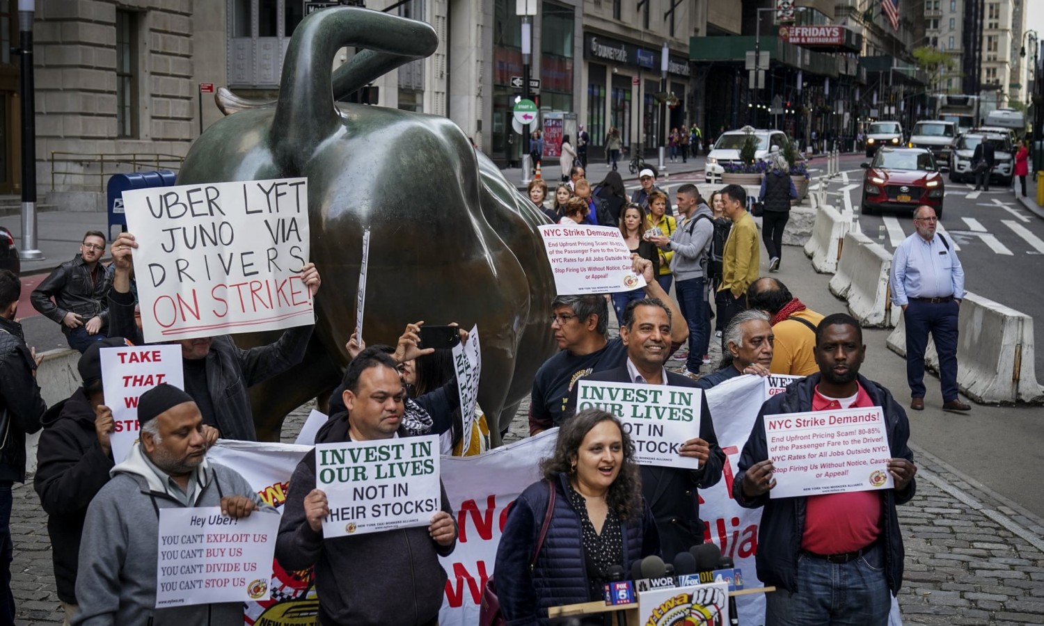 A small group of independent drivers and supporters protest against Uber and other app-based ride-hailing companies near the Wall Street charging bull on Wednesday. Photograph: Drew Angerer/Getty Images