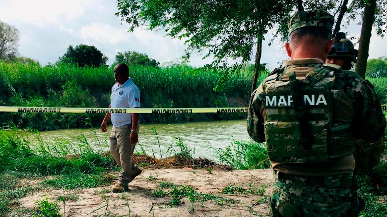 Mexican authorities walk along the Rio Grande bank where the bodies of father and child were found.