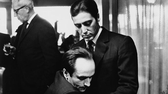 JOHN SPRINGER COLLECTION/GETTY / Frederico "Fredo" Corleone holds his brother Michael Corleone at a family funeral in Francis Ford Coppola's The Godfather: Part II