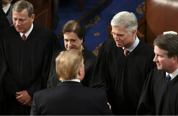 US President Donald Trump shakes hands with US Supreme Court Justice Neil Gorsuch as Justices Brett Kavanaugh, Elena Kagan, and John Roberts stand by following Trump’s State of the Union address at the US Capitol in Washington, DC, on February 5, 2019. Ma