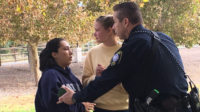 Two students talk to a police officer at Central Park following a shooting at Saugus high school in Santa Clarita, Calif. Nov. 14, 2019. ROBERT HANASHIRO, USA TODAY