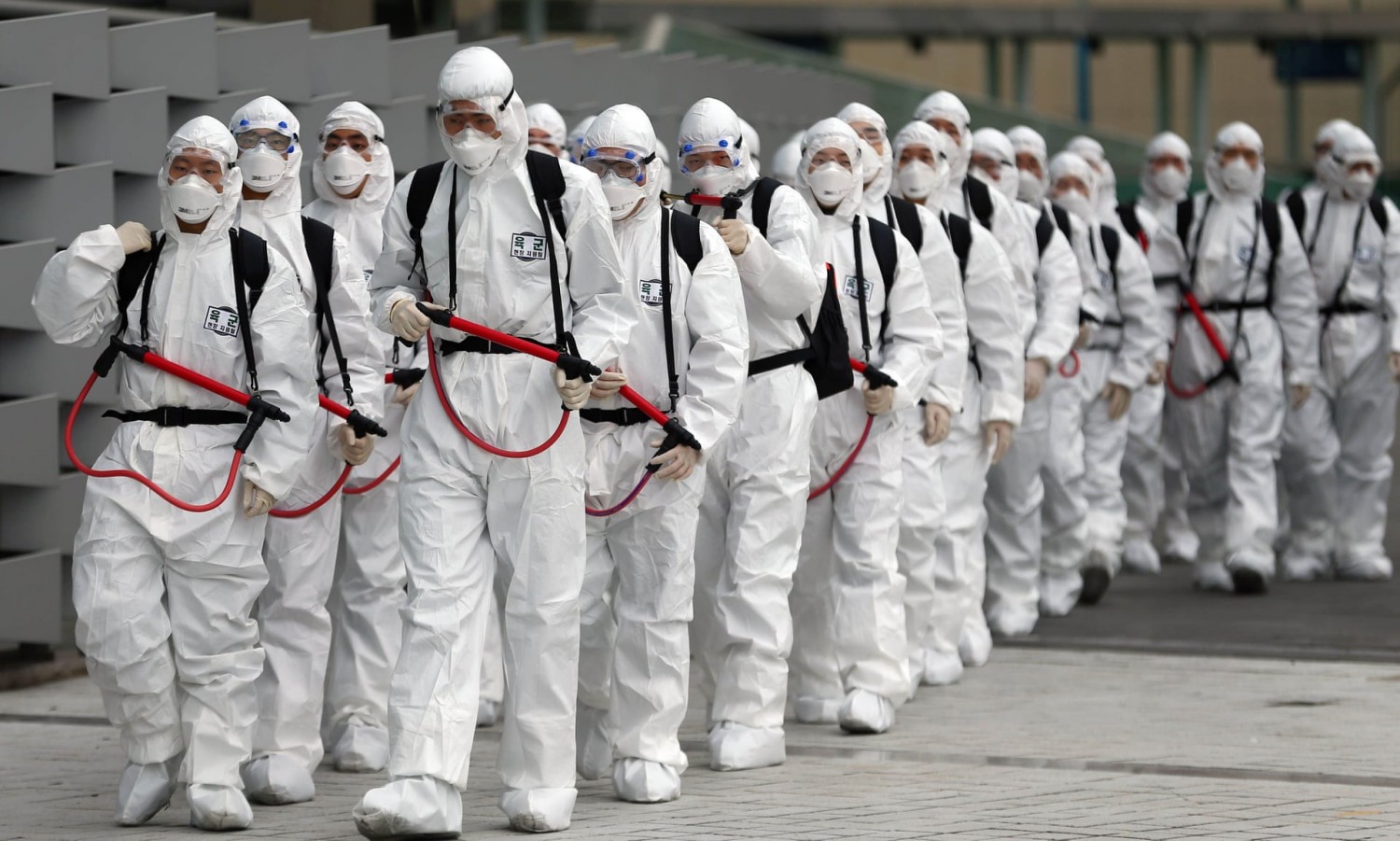 South Korean soldiers wearing protective gear spray disinfectant as part of preventive measures against the spread of the Covid-19 coronavirus in Daegu. Photograph: YONHAP/AFP via Getty Images