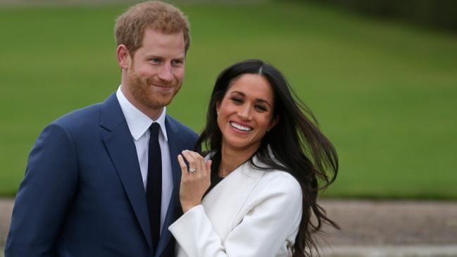 Britain's Prince Harry stands with his fiancee US actor Meghan Markle as she shows off her engagement ring while they pose for a photograph in the Sunken Garden at Kensington Palace in west London. Picture: Daniel Leal-OlivasSource:AFP