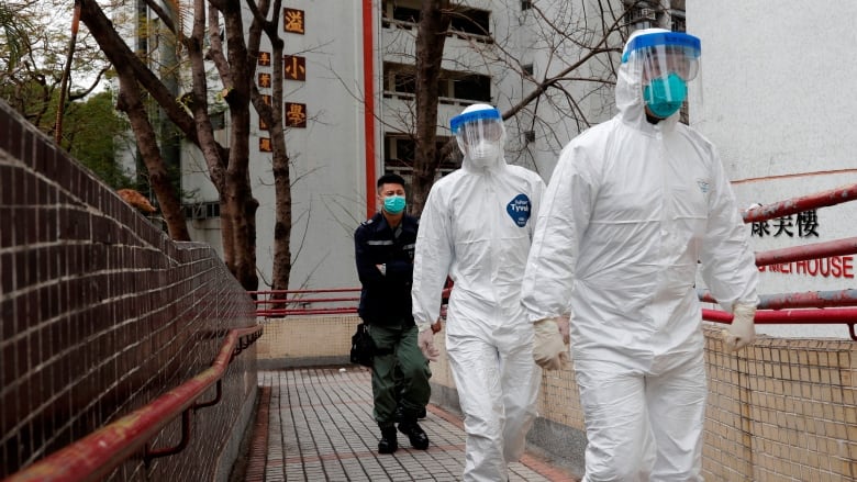Health workers in protective gear evacuate a public housing building outside Hong Mei House at Cheung Hong Estate in Hong Kong on Tuesday. (Tyrone Siu/Reuters)