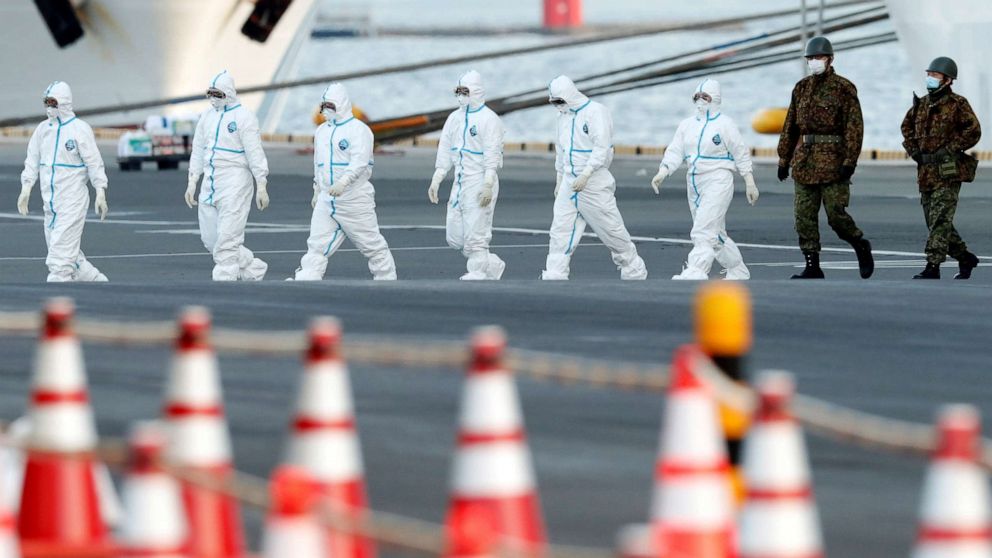 Kim Kyung Hoon/ReutersWorkers and army officers wearing protective suits walk away from the Diamond Princess cruise ship, as they prepare to transfer passengers tested positive for the novel coronavirus, at Daikoku Pier Cruise Terminal in Yokohama,