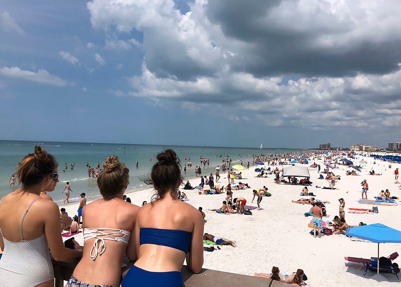 People gather at Clearwater Beach in Florida, Monday, despite growing coronavirus concerns. The state's governor has left it to local communities to decide if they would restrict access to beaches. In other parts of the U.S. such as San Francisco, pe