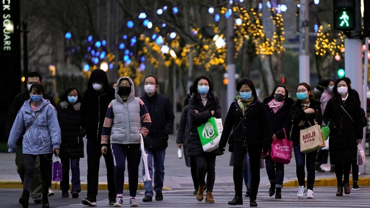 People wearing protective face masks walk at a crossroads as the country is hit by an outbreak of the novel coronavirus, in Shanghai, China March 4, 2020. © Aly Song, Reuters