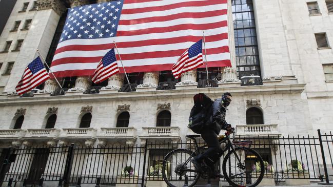 A delivery worker rides his electric bicycle past the New York Stock Exchange, Monday, March 16, 2020. Picture: AP /John Minchillo.Source:AP