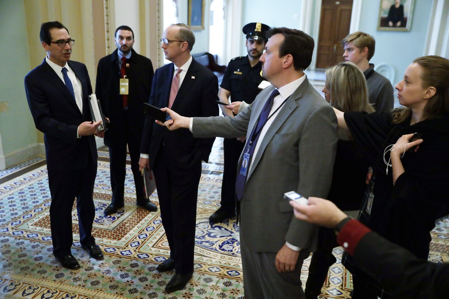  Treasury Secretary Steven Mnuchin, left, speaks to reporters at the Capitol about the coronavirus stimulus bill.