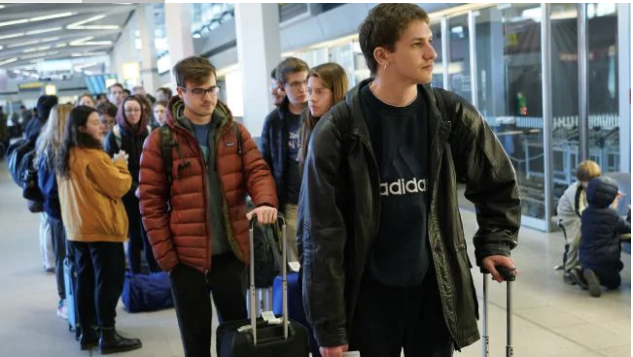 Passengers, including American citizen Dylan Clairmont (R), 20, wait to board the last direct United Airlines flight from Berlin to New York at Tegel Airport before the Trump European travel ban went into effect on March 13, 2020. Picture: Se