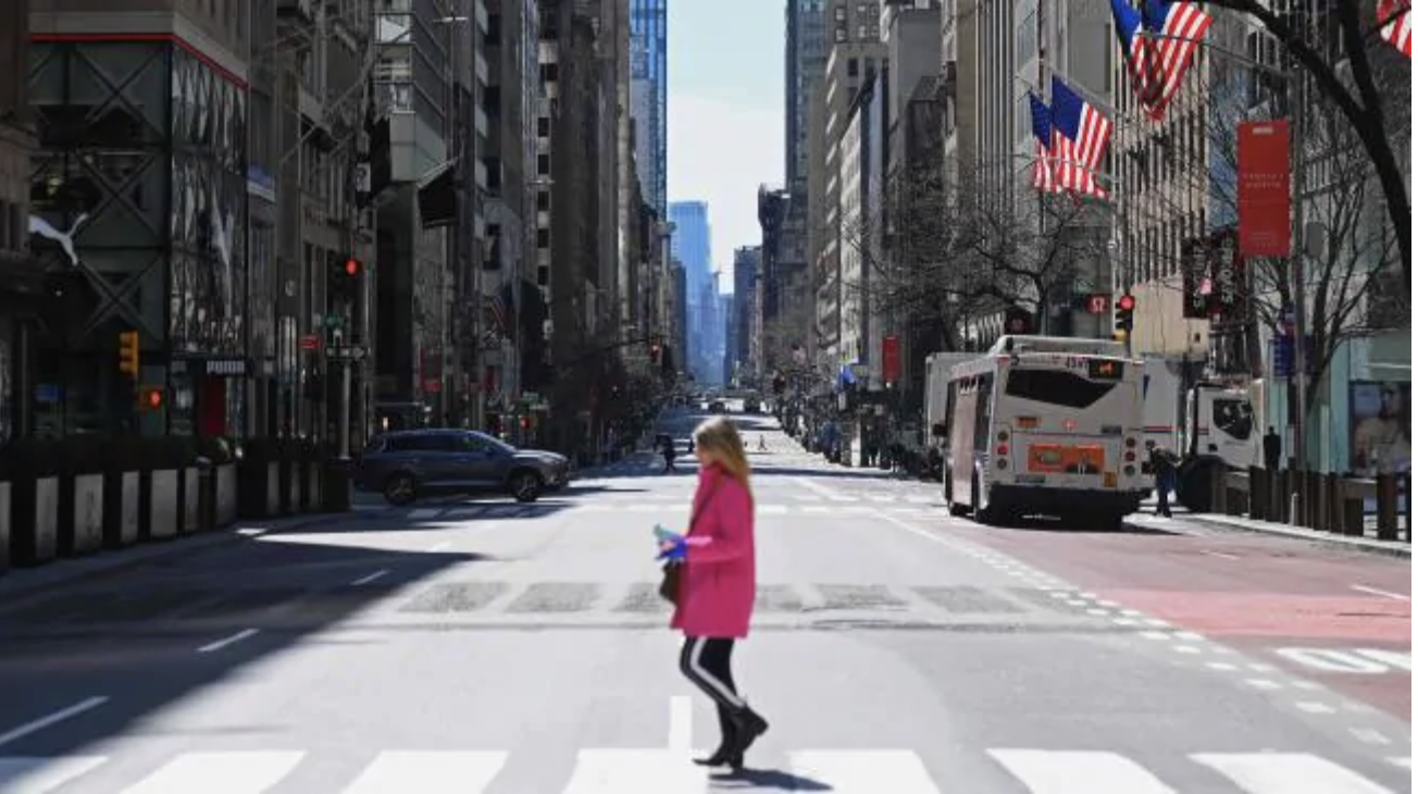 A woman crosses Fifth Avenue in New York City, where the coronavirus is reportedly claiming one life every 17 minutes. Picture: Angela Weiss / AFP.Source:AFP