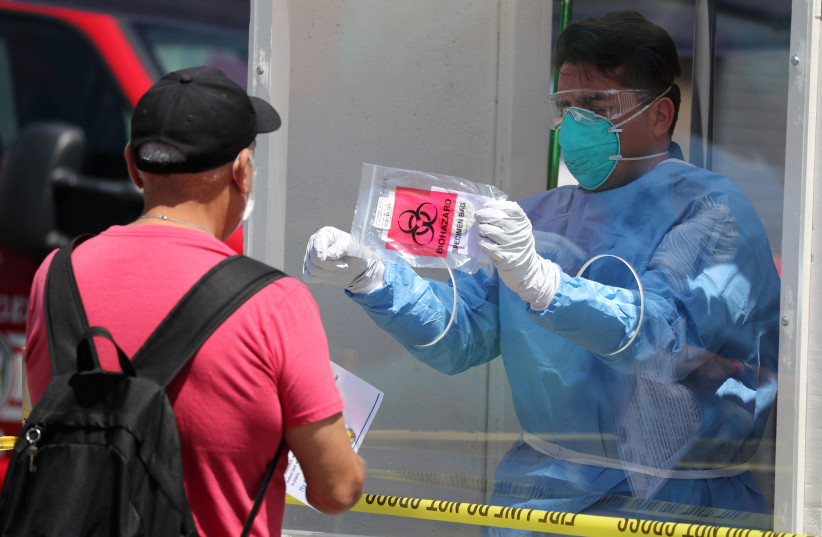 A man is tested for coronavirus disease (COVID-19) at a Los Angeles fire department testing station for the homeless on Skid Row, in Los Angeles (photo credit: REUTERS/LUCY NICHOLSON)