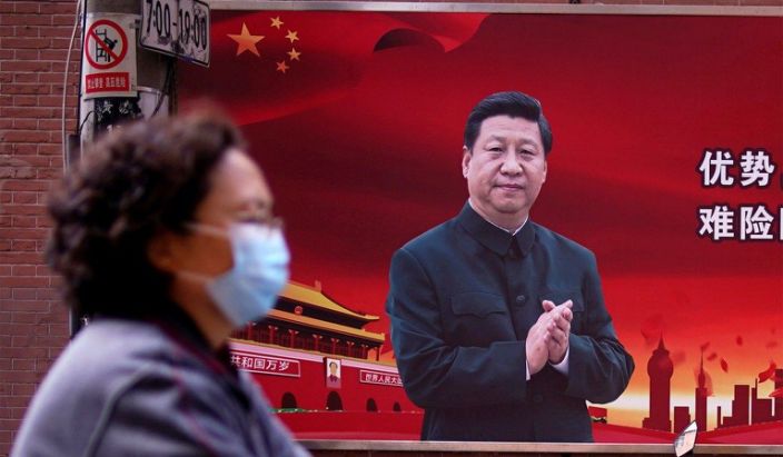 A woman walks past a portrait of Chinese President Xi Jinping as the country is hit by the coronavirus, Shanghai, China, March 12, 2020. (Aly Song/Reuters)